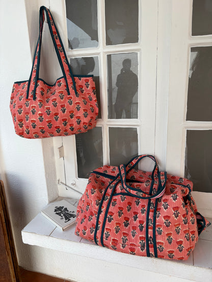 Two patterned bags on a windowsill with a white frame.