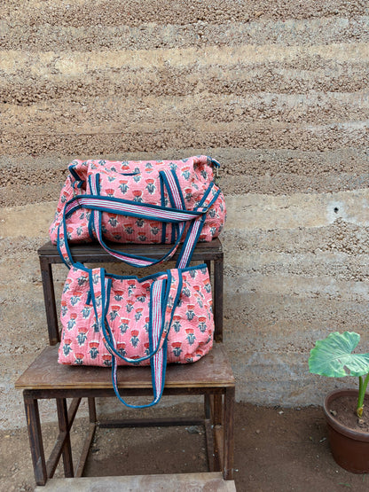 Pink patterned bags on a wooden chair against a textured wall.