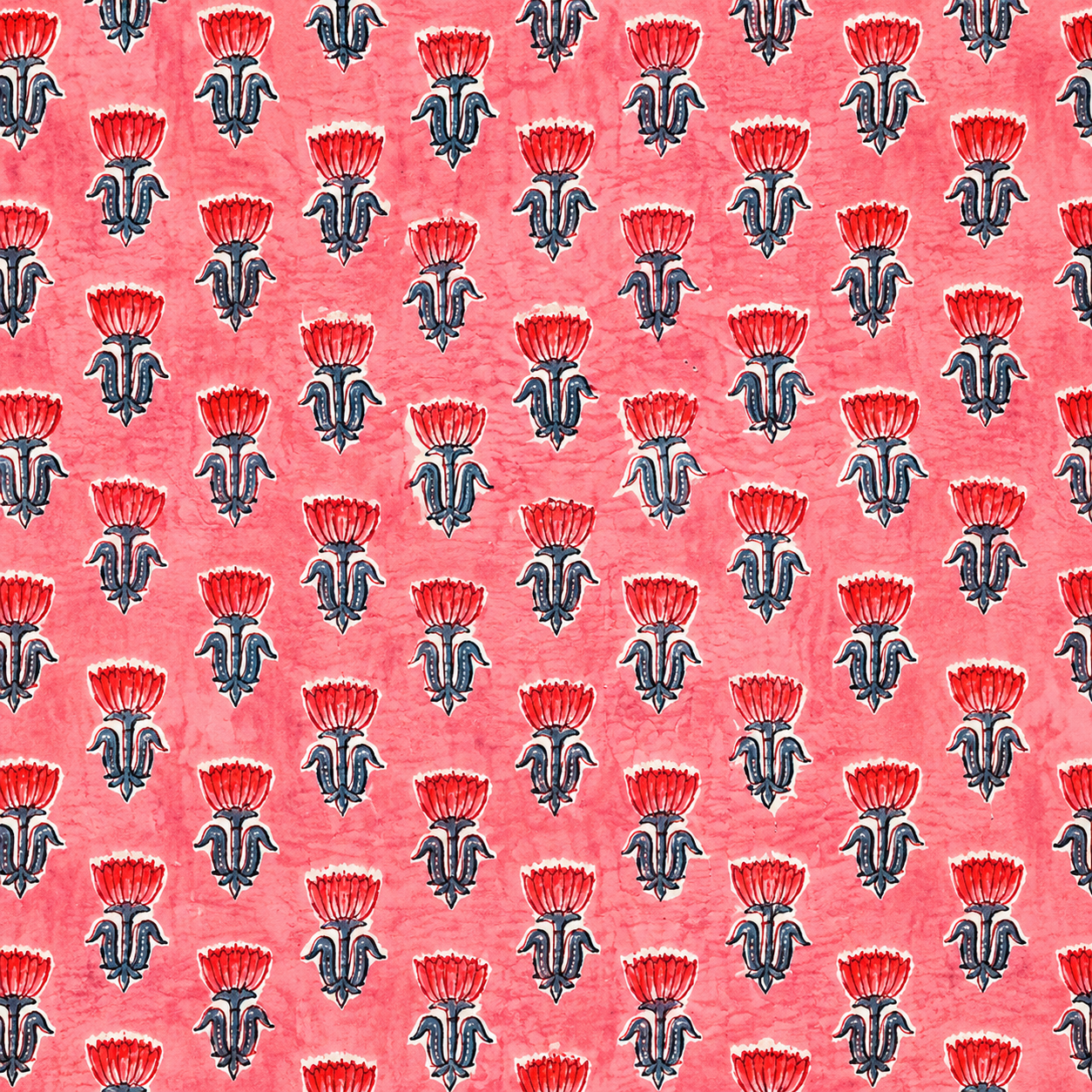 Patterned fabric with red and black floral design on a pink background